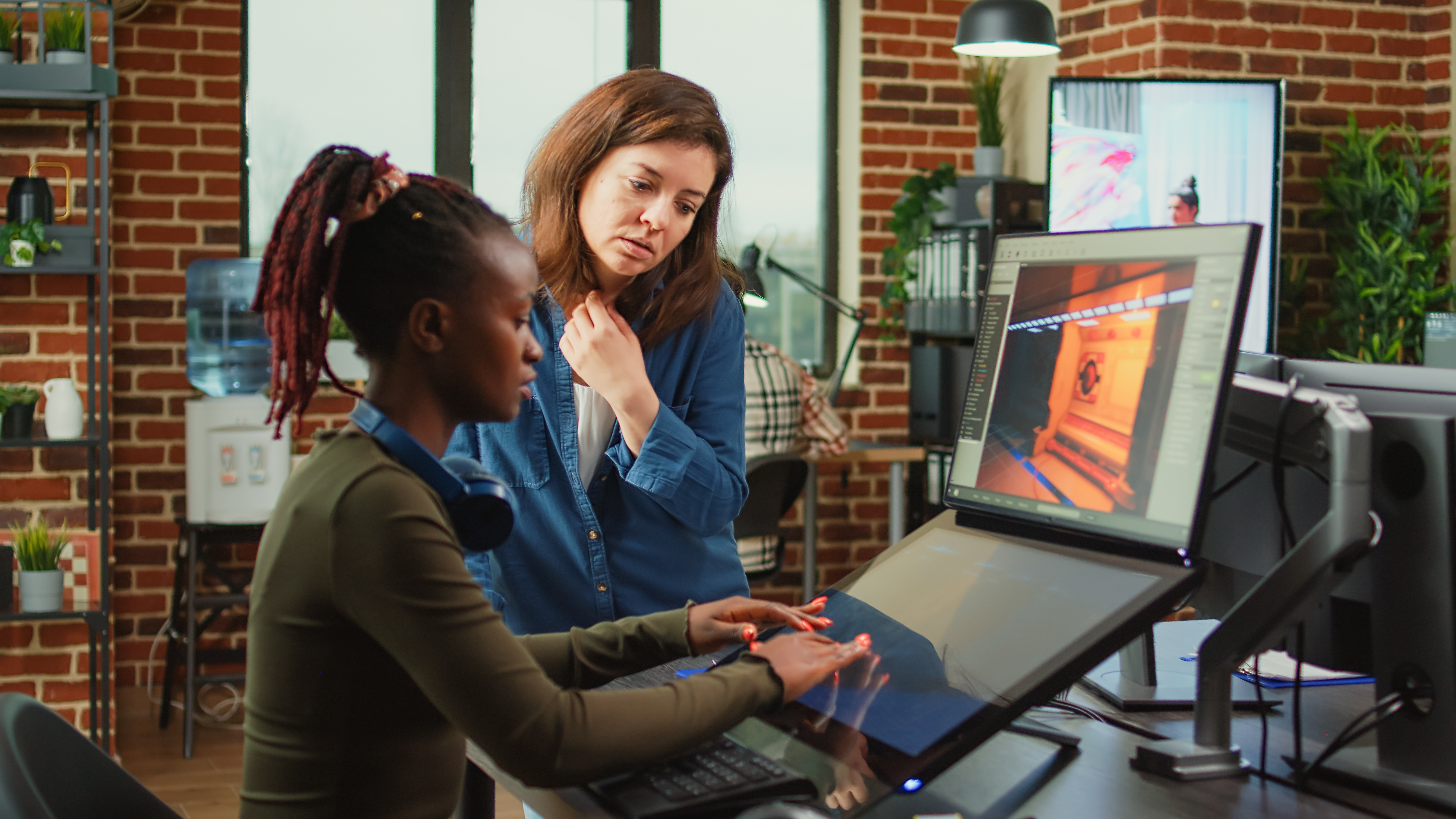 Diverse colleagues analyzing game developing electronics